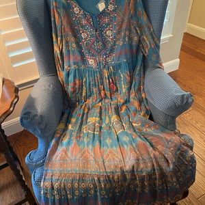 Beautiful dress with much detail such as mirrors and tassel ties at the neck.